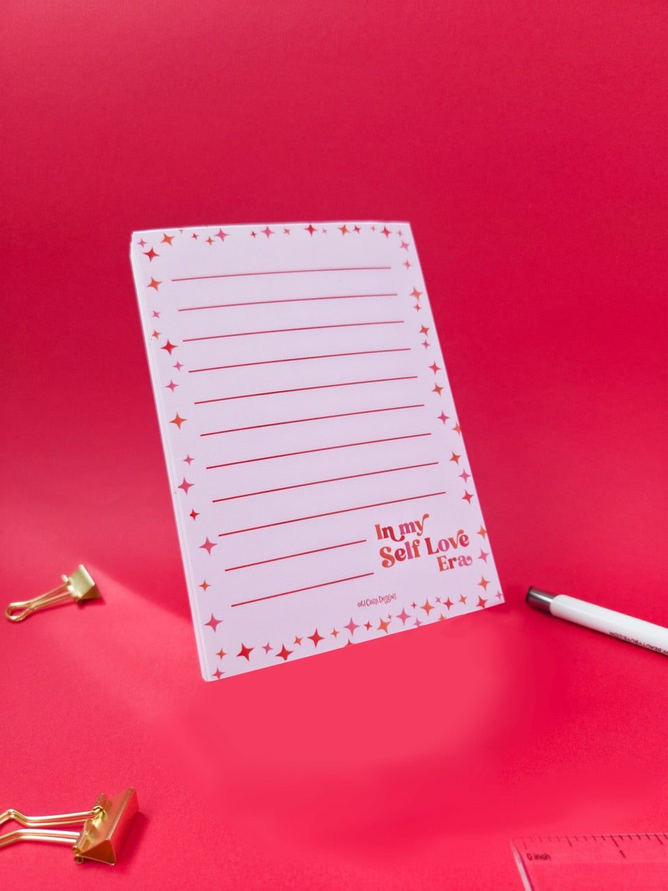 Notebook with lined pages and decorative text on a red background